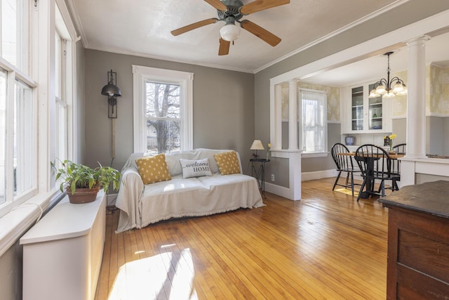 bedroom with light wood-style flooring, decorative columns, and ornamental molding