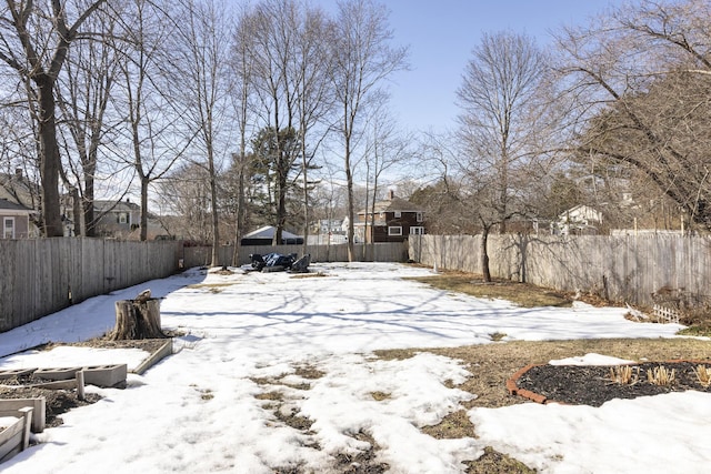 snowy yard featuring a fenced backyard