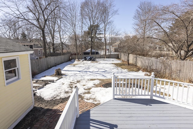 snow covered deck featuring a fenced backyard