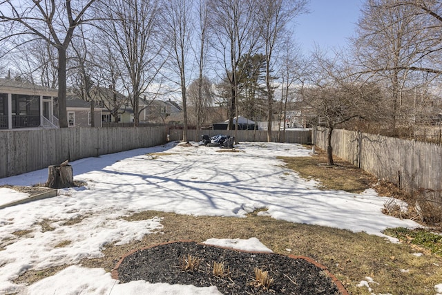 snowy yard with a fenced backyard