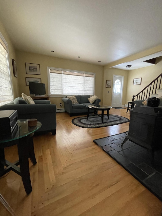 living area featuring parquet flooring, stairs, and a baseboard heating unit