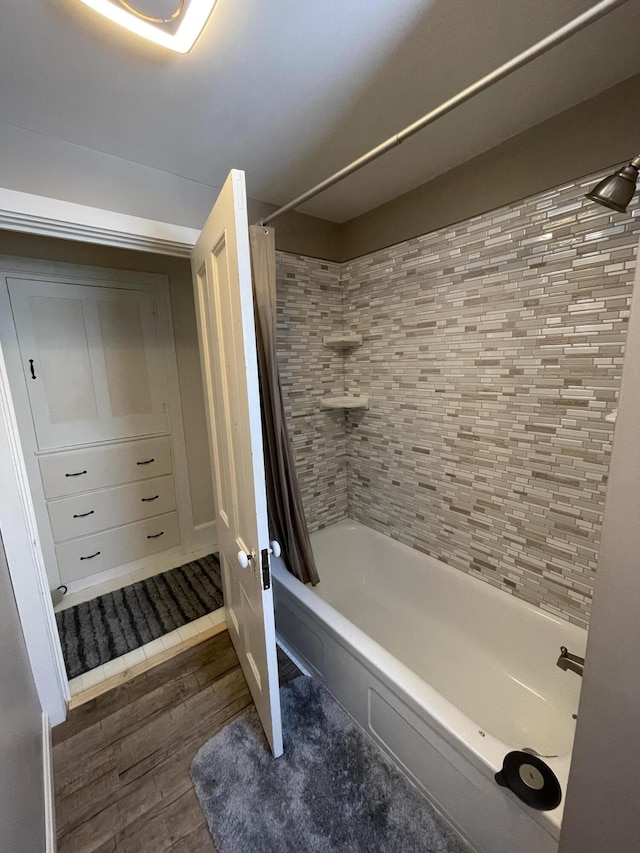 full bathroom with shower / tub combo and wood finished floors