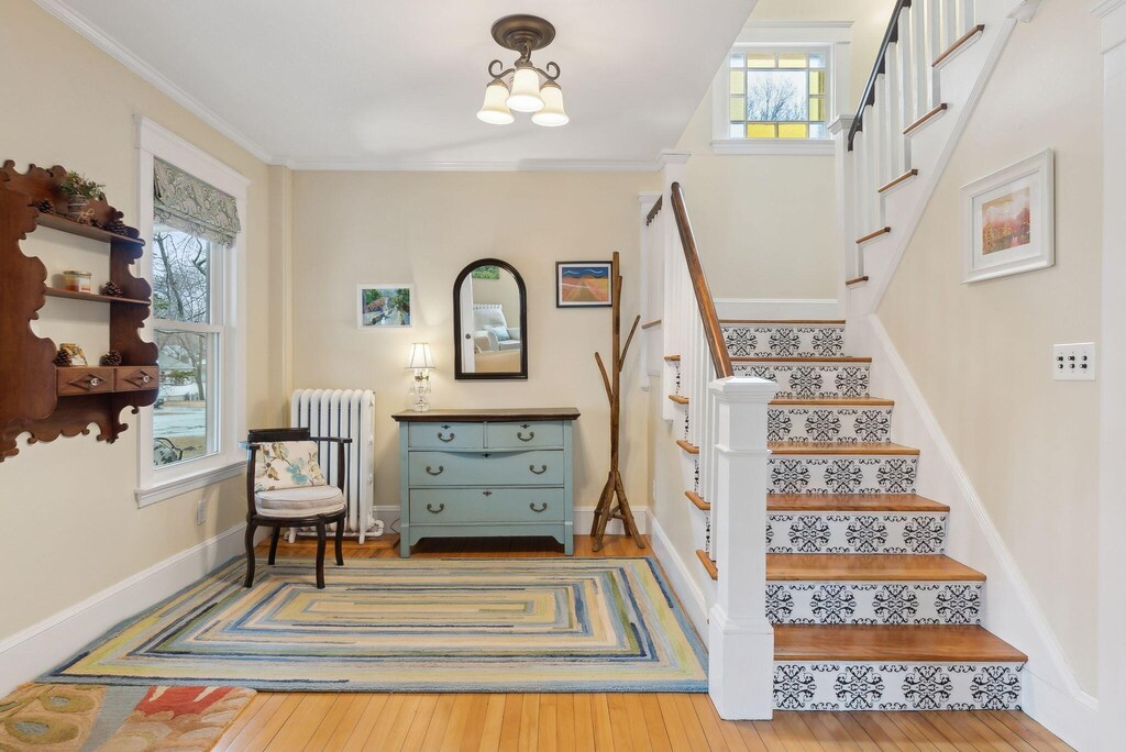 41 Caleb St, Portland, ME 04102 - stairway featuring ornamental molding, wood-type flooring, baseboards, and radiator