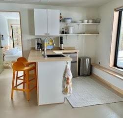 kitchen with open shelves, finished concrete flooring, light countertops, and a sink