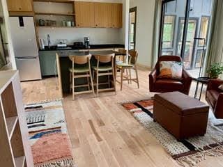 kitchen featuring open shelves, a breakfast bar area, light wood-style flooring, and freestanding refrigerator