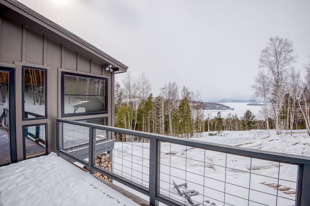 snow covered back of property featuring a mountain view