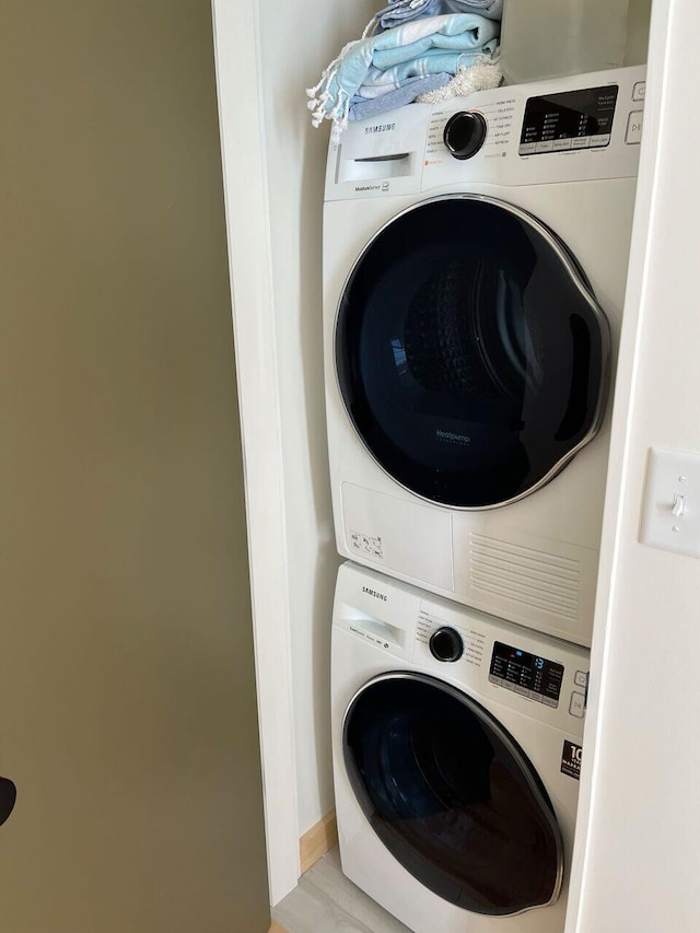 washroom featuring stacked washer / drying machine