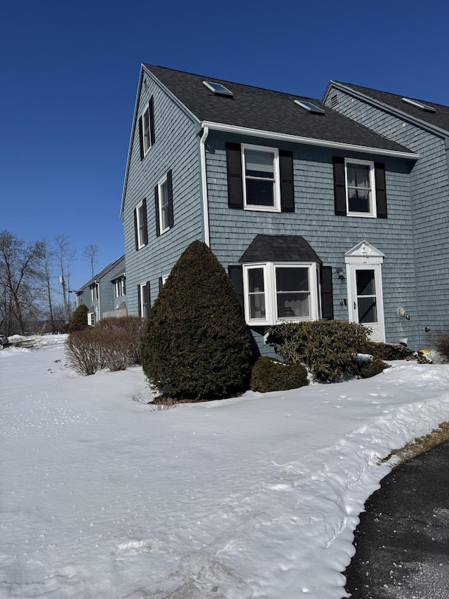 colonial-style house featuring a shingled roof