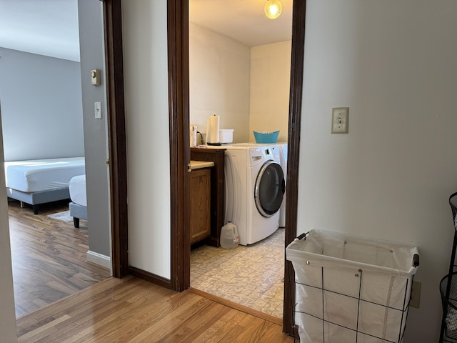 washroom with washer / dryer, light wood-style flooring, laundry area, and baseboards