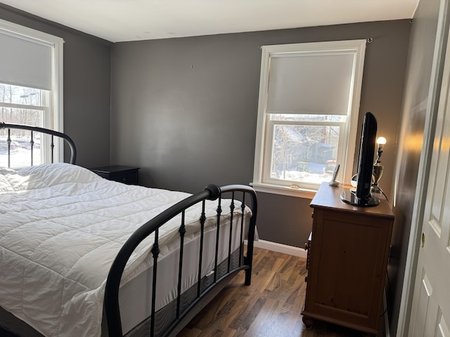 bedroom with dark wood finished floors and baseboards