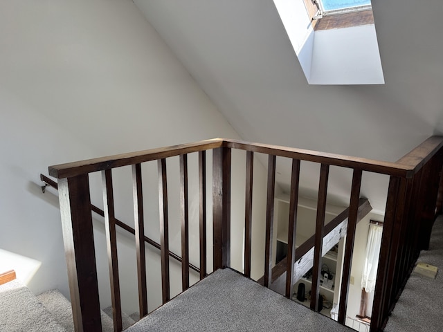 stairs with lofted ceiling with skylight and carpet flooring