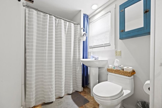 full bath with a shower with shower curtain, toilet, and a sink