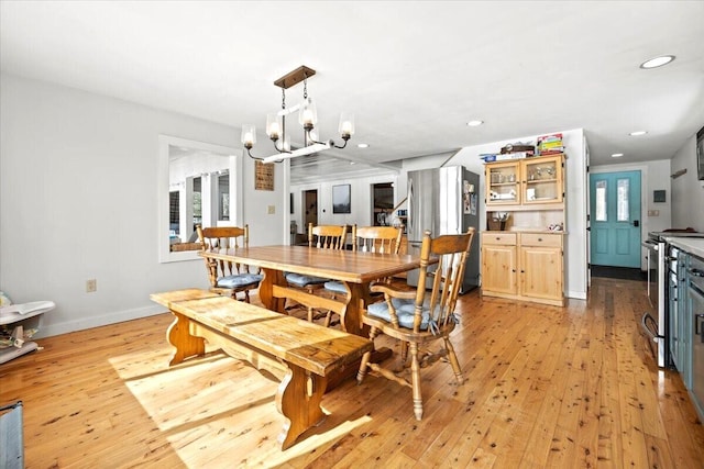 dining room featuring light wood finished floors, a notable chandelier, recessed lighting, and baseboards