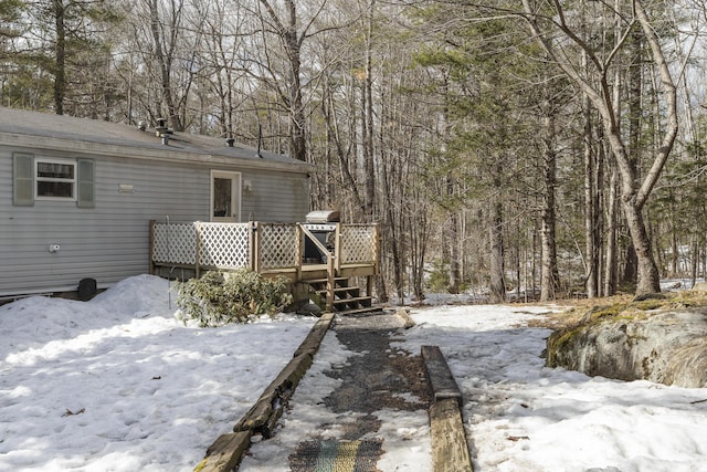 exterior space with a wooden deck and a wooded view