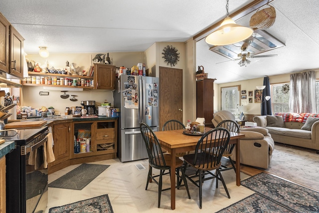 dining space featuring vaulted ceiling, a ceiling fan, visible vents, and a textured ceiling