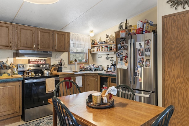 kitchen featuring under cabinet range hood, open shelves, brown cabinetry, and appliances with stainless steel finishes