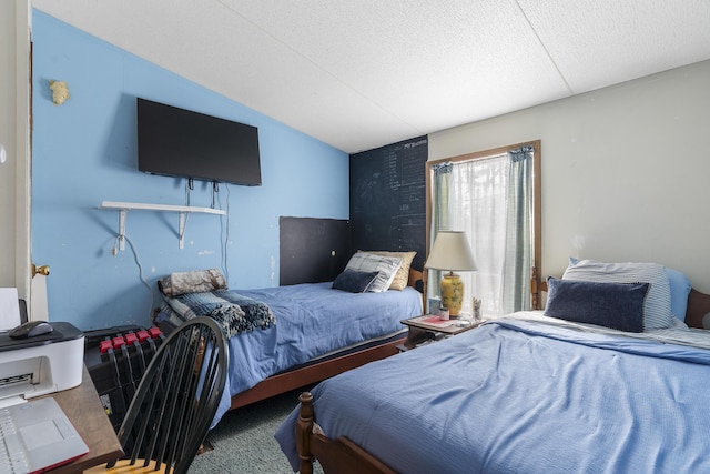 bedroom featuring lofted ceiling, carpet floors, and a textured ceiling