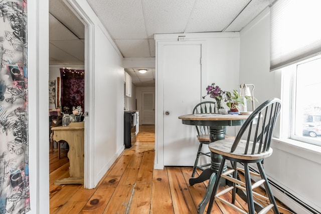 interior space featuring a paneled ceiling and light wood-style floors