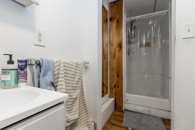 full bathroom with vanity, a shower with shower curtain, and wood finished floors