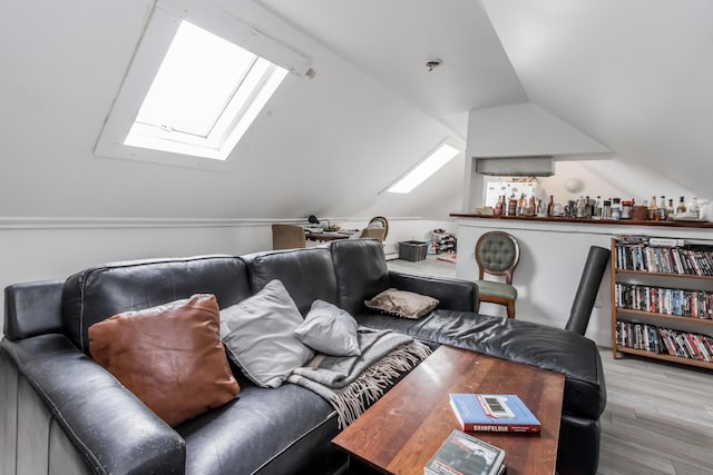 home theater with a wealth of natural light, vaulted ceiling, and wood finished floors