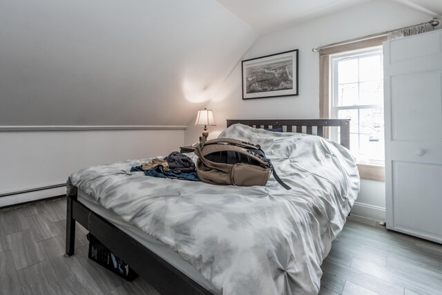 bedroom featuring lofted ceiling and baseboard heating