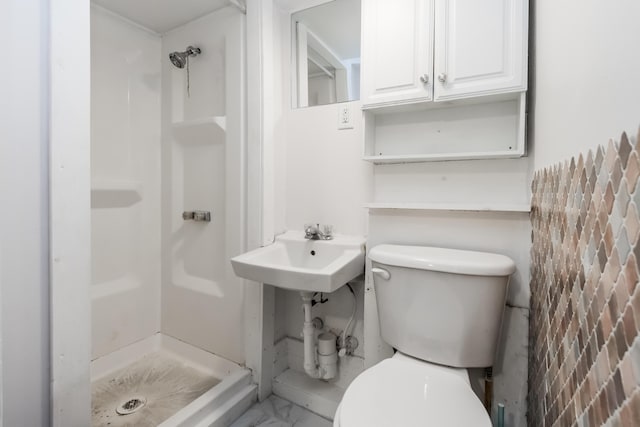 full bathroom featuring a stall shower, a sink, and toilet