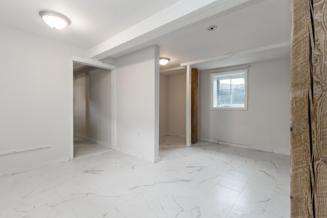 basement featuring marble finish floor and baseboards