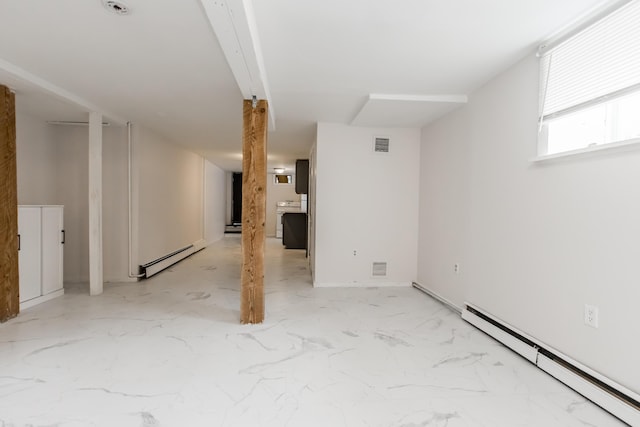 below grade area featuring marble finish floor, a baseboard radiator, visible vents, and a baseboard heating unit