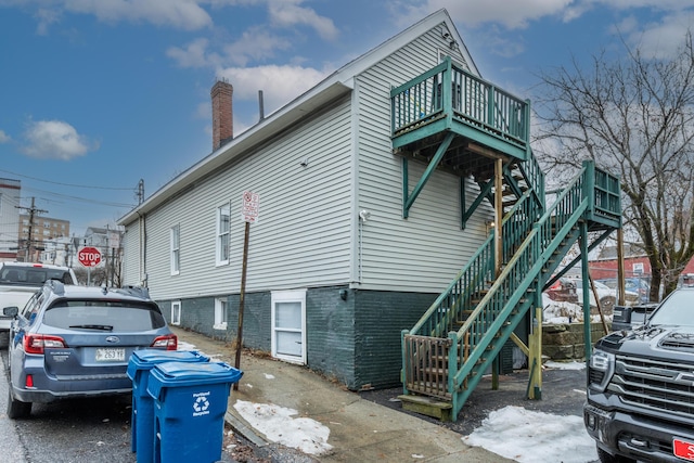 view of side of home featuring stairway and a chimney