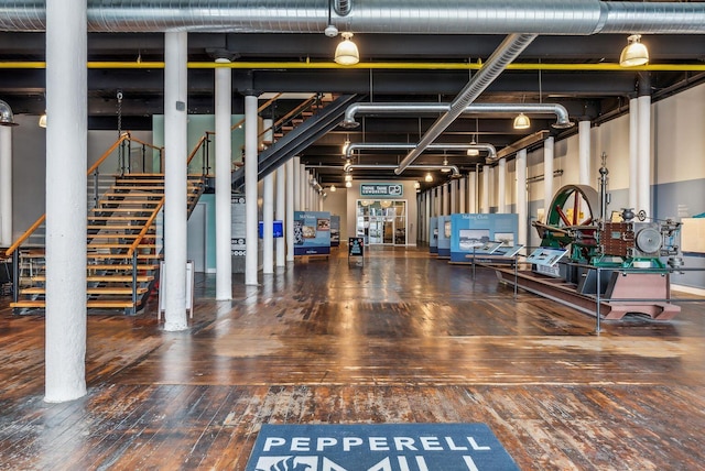 exercise room featuring a towering ceiling and hardwood / wood-style floors