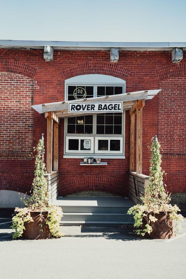 view of exterior entry featuring brick siding