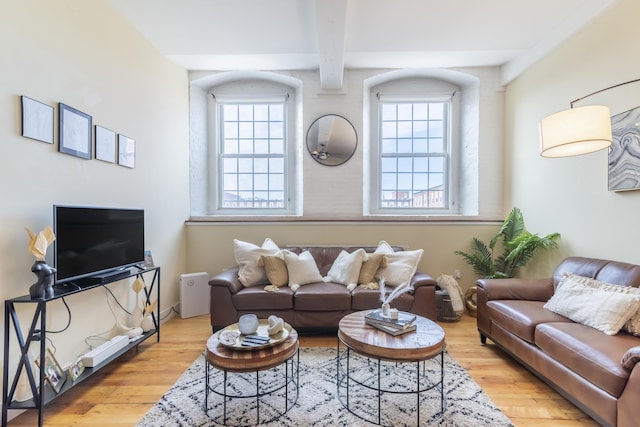 living room with beamed ceiling and wood finished floors