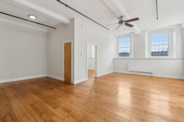 unfurnished room with light wood finished floors, baseboards, a ceiling fan, radiator, and beam ceiling