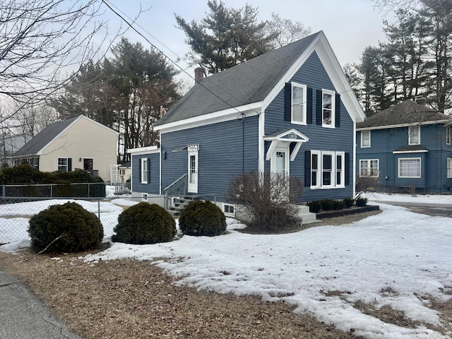 view of front of home featuring entry steps, a chimney, and fence