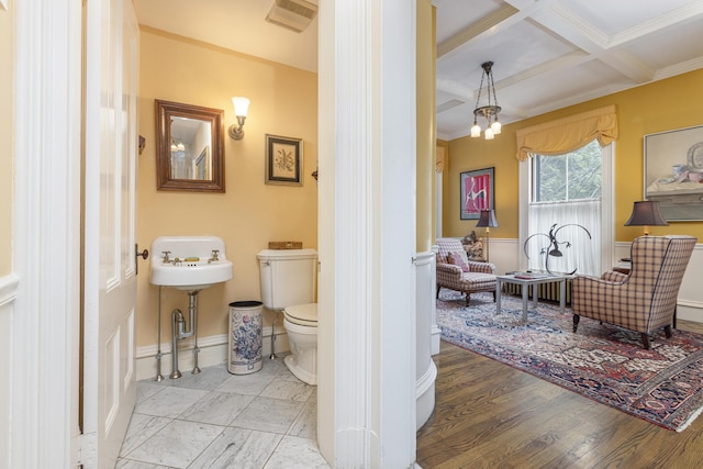 bathroom featuring coffered ceiling, toilet, baseboards, beam ceiling, and wood finished floors