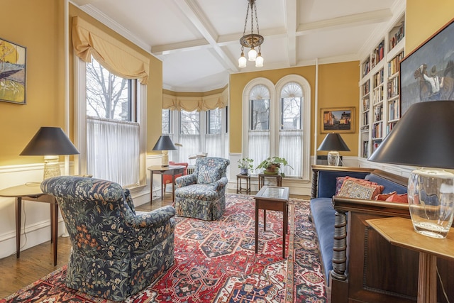 living area with coffered ceiling, beamed ceiling, crown molding, and wood finished floors