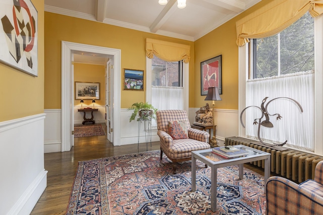 sitting room featuring a wainscoted wall, crown molding, wood finished floors, and beam ceiling