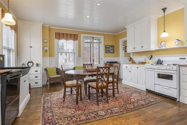kitchen featuring dishwasher, gas range gas stove, a wainscoted wall, and white cabinets
