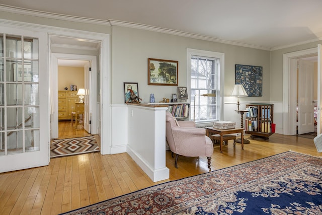 sitting room featuring ornamental molding and light wood-style floors