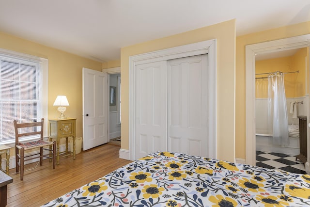 bedroom with a closet, baseboards, and light wood-style floors