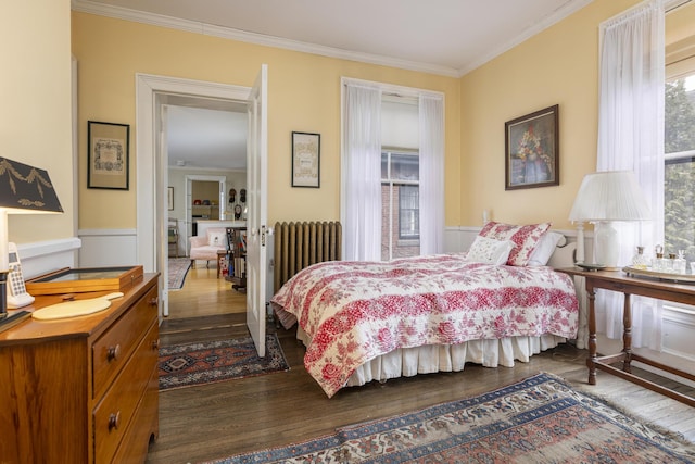 bedroom with dark wood-style flooring, radiator heating unit, and crown molding