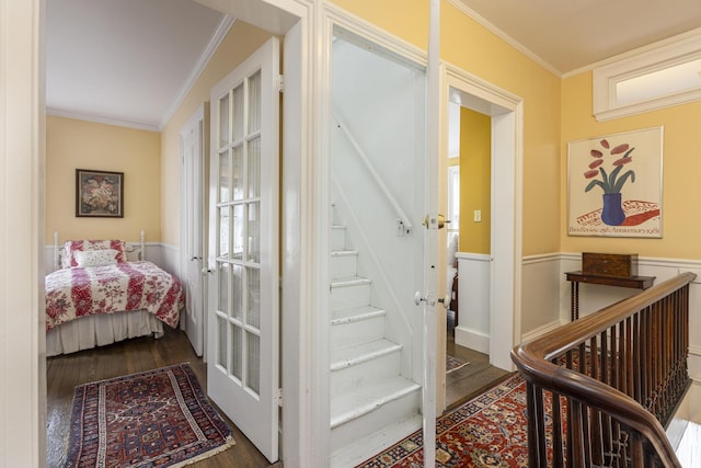 interior space featuring ornamental molding, wood finished floors, and wainscoting