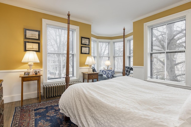 bedroom with radiator heating unit, crown molding, and wood-type flooring