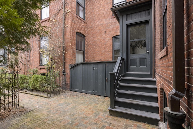 doorway to property with brick siding