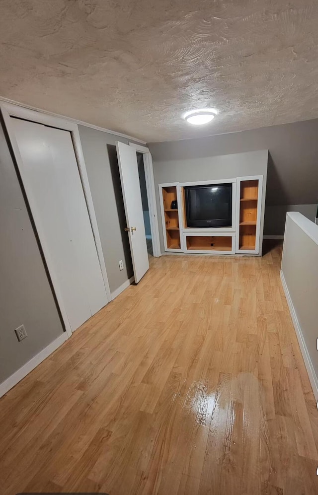 32 Maple St, Fairfield, ME 04937 - unfurnished living room with light wood-style flooring, a textured ceiling, and baseboards