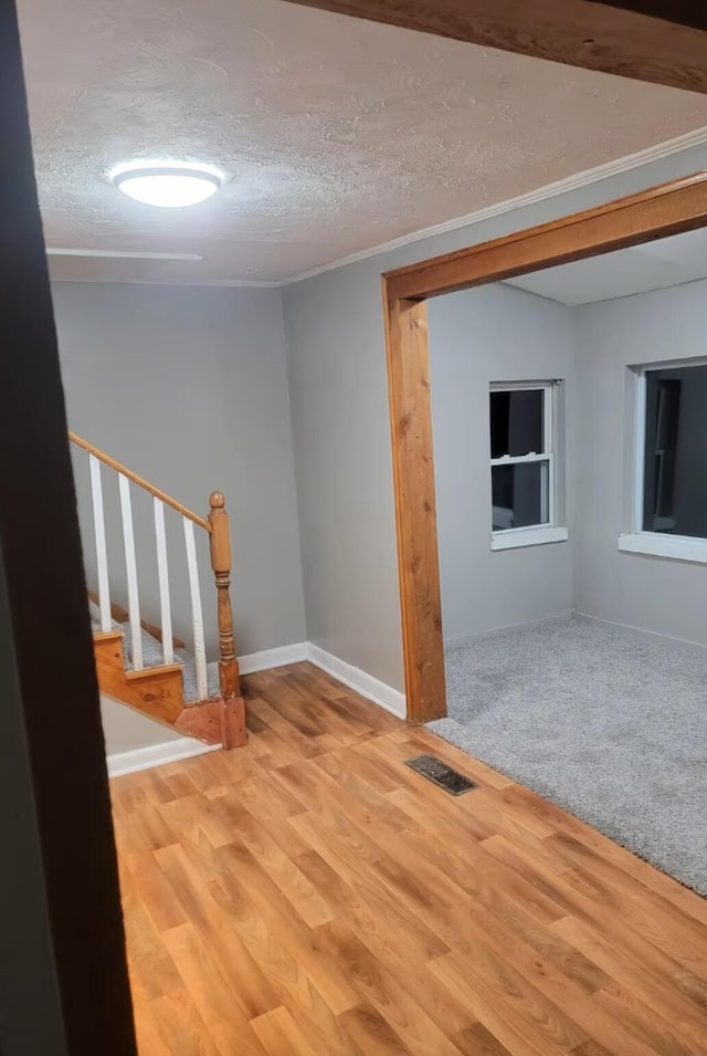 32 Maple St, Fairfield, ME 04937 - empty room featuring stairs, wood finished floors, a textured ceiling, and baseboards