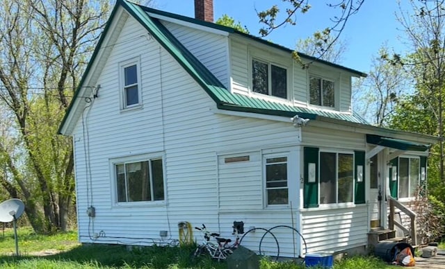 32 Maple St, Fairfield, ME 04937 - rear view of property with a chimney, entry steps, and metal roof