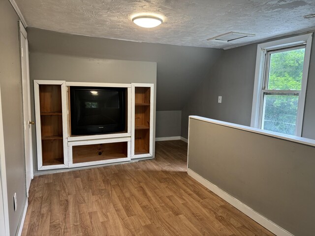32 Maple St, Fairfield, ME 04937 - additional living space featuring a textured ceiling, wood finished floors, attic access, and vaulted ceiling