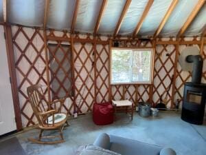 unfurnished living room featuring a wood stove and concrete floors