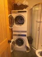 clothes washing area with laundry area and stacked washer / drying machine